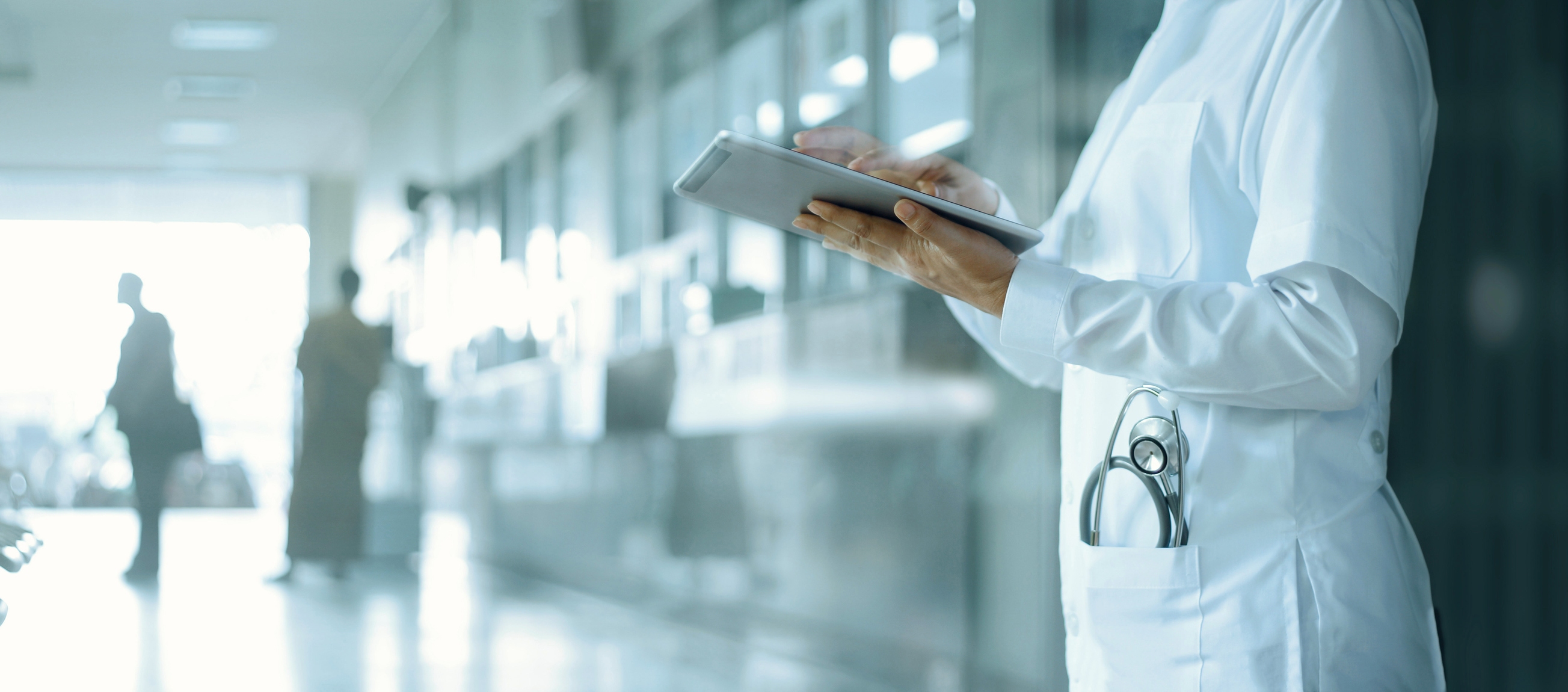 Doctor working on digital tablet on hospital background