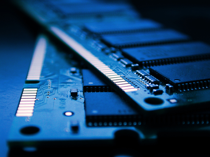 Close-up view of two memory modules with visible DRAM chips, circuit details and gold connectors.